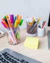 Colorful desk setup: markers, pens, sticky notes, and a keyboard. Vibrant hues. Royalty Free Stock Photo