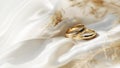 Wedding rings on white satin fabric background, closeup with copy space Royalty Free Stock Photo