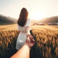 A woman leading a man into a beautiful field