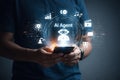 AI generated person holding smartphone with glowing ai agent interface and connected icons representing chatbot technology Royalty Free Stock Photo