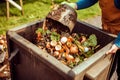 AI generated person scooping out food waste from a compost pile