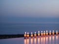 Serenity captured with lit candles arranged in a row at dusk.