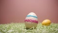 two colorful easter eggs on grass with pink and blue stripes Royalty Free Stock Photo