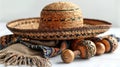 Woven sombrero with maracas and a fringed blanket on a white surface.