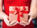 Ai generative. Christmas gift box with red ribbons in female hands Royalty Free Stock Photo