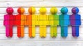 Colorful plastic figures arranged in rows on a white wooden background, resembling people.