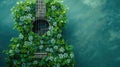 A guitar overgrown with vibrant green plants against an aqua background. Royalty Free Stock Photo