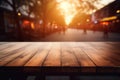 Empty wooden table top in the outdoors cafe with blur background of the sunset city