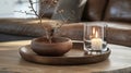 Tranquil home decor with a candle and dried branches on wood.