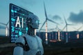 AI robot standing in front of a computer screen, many wind generators in the background Royalty Free Stock Photo