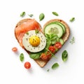 Sandwich for Valentine\'s Day in shape of a heart. Fried toast with fried eggs, avocado, salmon, cut cherry tomatoes, spices