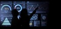 AI Using. Silhouetted analysts interact with a large AI data display Royalty Free Stock Photo