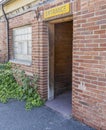 ENTRANCE sign above open door of red brick commercial building shows a dark wood interior. Royalty Free Stock Photo