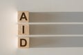 AID word written on wood block. Concept. Help, assistance, support Royalty Free Stock Photo