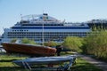 An AIDA cruise liner with passengers passes boats onshore at Elbe