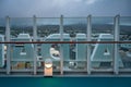 AIDA Logo attached to the outside railing of AIDA Bella cruise ship, city of Iceland in the background, in the evening