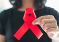 Aids red ribbon on woman`s hand support for World aids day and national HIV/AIDS and aging awareness month concept Royalty Free Stock Photo