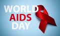 AIDS ribbon on a blue background with text. Red ribbon, symbol of World AIDS Day or HIV Awareness Month and concept of healhcare Royalty Free Stock Photo