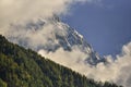 Aiguilles mountain range peaks and green forest through the clouds. Chamonix, France Royalty Free Stock Photo