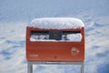 AIJEN, NETHERLANDS - DECEMBER 6, 2021: Official orange postbox covered with fresh snow