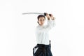 Aikido master practices defense posture. Healthy lifestyle and sports concept. Woman in white kimono on white background