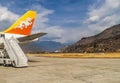 Ail and ladder of Drukair Ã¢â¬â Royal Bhutan Airlines Airplane Airbus A319s in Paro Airport. Himalaya mountais and bhutanese houses