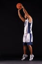 Aiming for a golden shot. Studio shot of a basketball player against a black background.