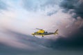 Air Ambulance helicopter Yellow medical emergency chopper taking off at dusk amazing dramatic storm sky as respond to 999 incident Royalty Free Stock Photo