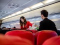 Air asia, Bangkok - Nov 22, 2018: Air asia flight attendant serve food and drinks to passengers on board Royalty Free Stock Photo