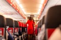 Air Asia flight attendant serve food and drinks to passengers on board. Royalty Free Stock Photo