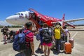 Tourist passengers are getting on an Air Asia Low-Cost Airlines aircraft