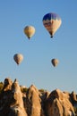 Air balloons festival in Cappadocia. Balloons flying over amazing shaped sandstone rocks Royalty Free Stock Photo
