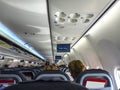 Airplane interior taking off with passengers seated and perspective view of the seats and overheads. All Royalty Free Stock Photo