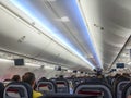 Airplane interior taking off with passengers seated and perspective view of the seats and overheads. All Royalty Free Stock Photo