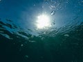 Air bubbles in clean clear sea blue water with sun rays Royalty Free Stock Photo