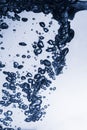 Air bubbles rising in fresh blue water on neutral gradient background