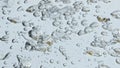 Air bubbles rising water surface closeup. Bubbling mineral liquid in light