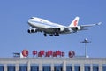 Air China Cargo Boeing 747-412BCF, B-2453 skims over China Aviation Oil Corp. building, Beijing, China Royalty Free Stock Photo