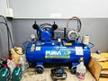 Air compressor in Tool room with with tools at station for vehicle technical servicing.