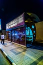 An air conditioned bus stop in Dubai with a tourist reflection in the glass
