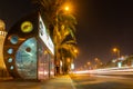 Air-conditioned RTA bus stop in Dubai at night on a busy road.