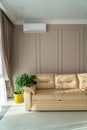 Air conditioner above sofa and pot plant in living room Royalty Free Stock Photo