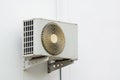 Air conditioner compressor unit on white wall. Royalty Free Stock Photo