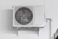 Air conditioner compressor unit on white wall. Royalty Free Stock Photo
