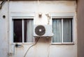 Air conditioner outdoor unit installed between two windows Royalty Free Stock Photo