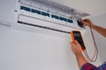 Air conditioner repair and maintenance. The engineer diagnoses the electrical part of the indoor unit of the air conditioner with