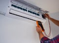 Air conditioner repair and maintenance. The engineer of the service organization carries out maintenance of the indoor unit of the Royalty Free Stock Photo