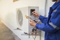 Air conditioner repairman using electricity meter to check air conditioner operation, maintenance concept Royalty Free Stock Photo