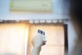 An air conditioner in a room with a young person using a remote control is turning on Royalty Free Stock Photo