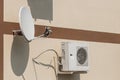 Air conditioner and satellite dish on the wall of a modern home on the street outdoor Royalty Free Stock Photo
